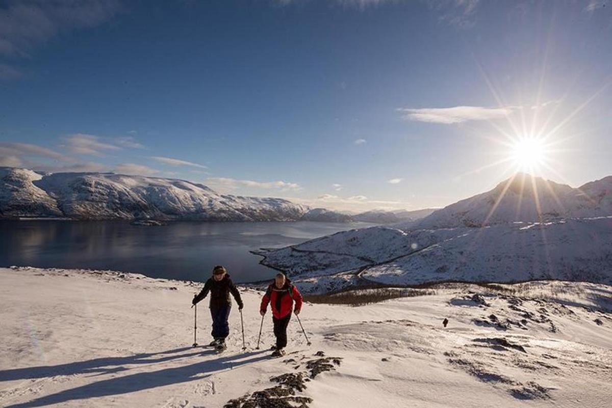 two people cross country skiing on a snow covered mountain