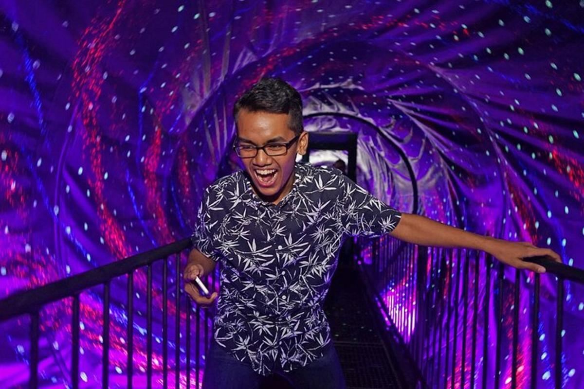 a man holding a cell phone in a purple room