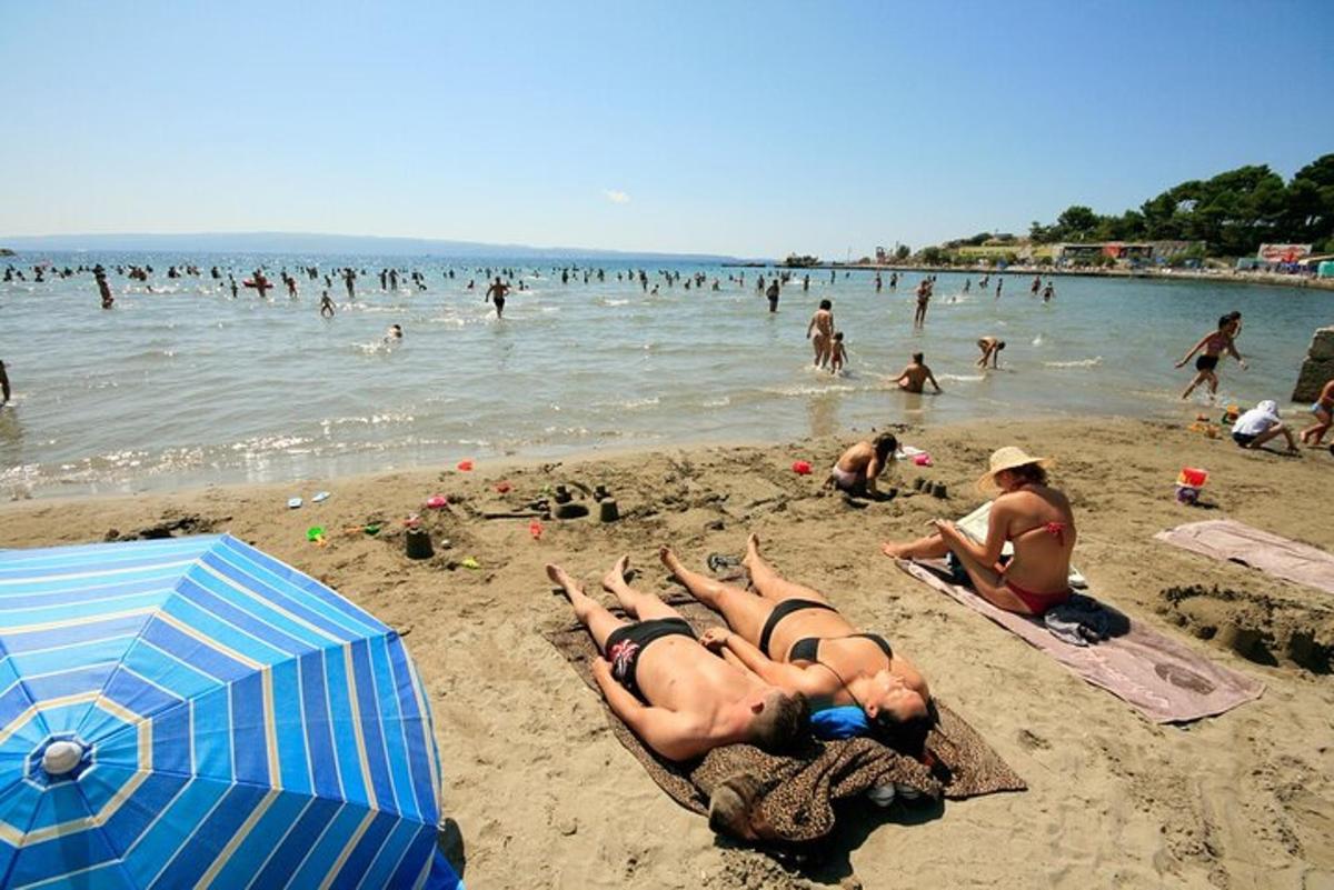 eine Gruppe von Menschen, die im Sand am Strand liegen