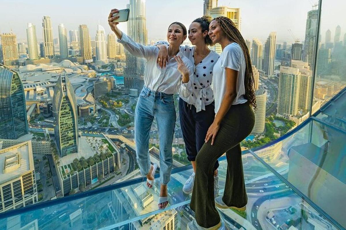 three women taking a picture on top of a skyscraper