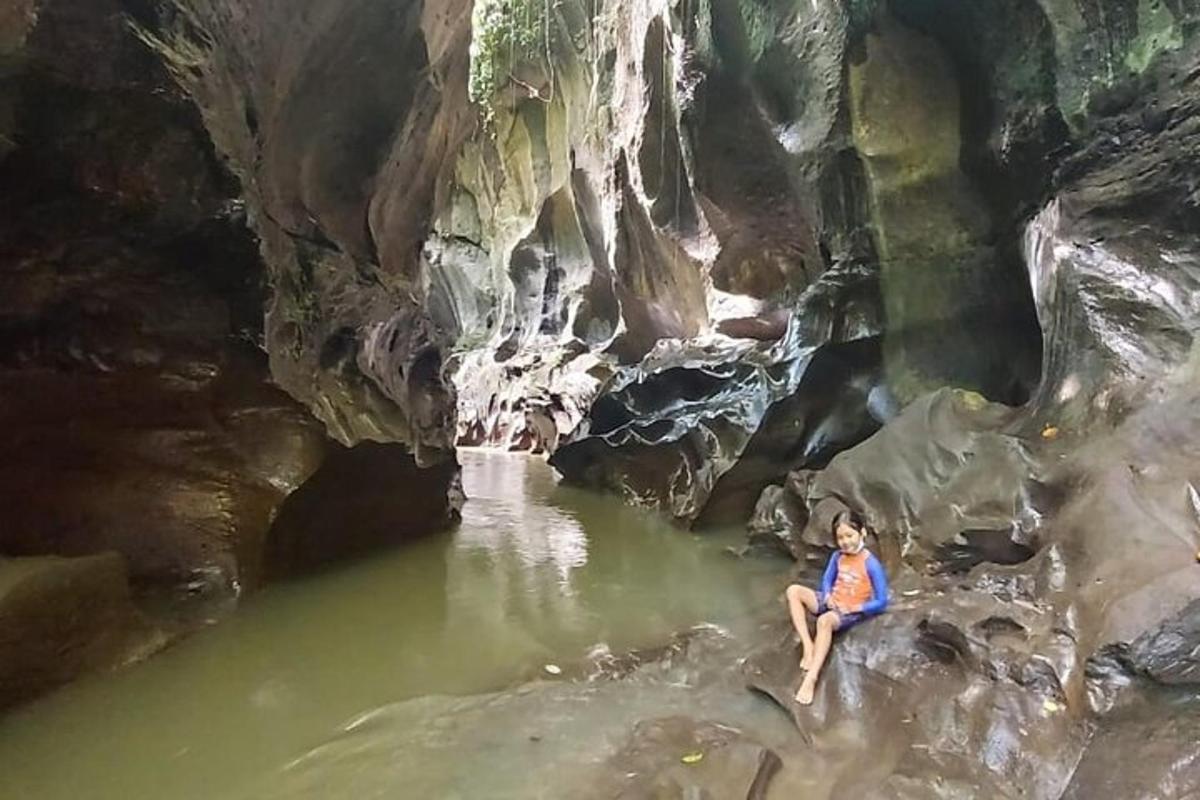 eine Frau, die in einem Wasserbecken in einer Höhle sitzt