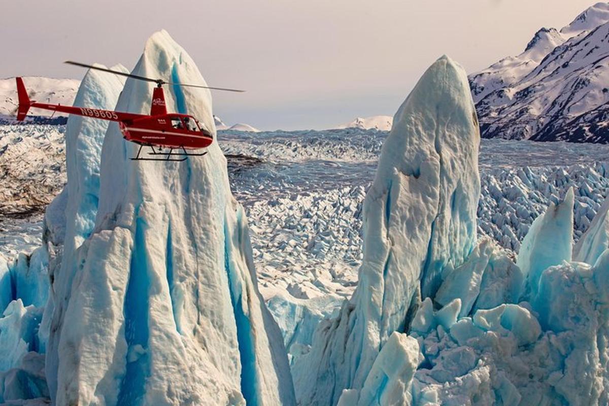 bir helikopter karla kaplı bir buzdağının üzerinden uçuyor