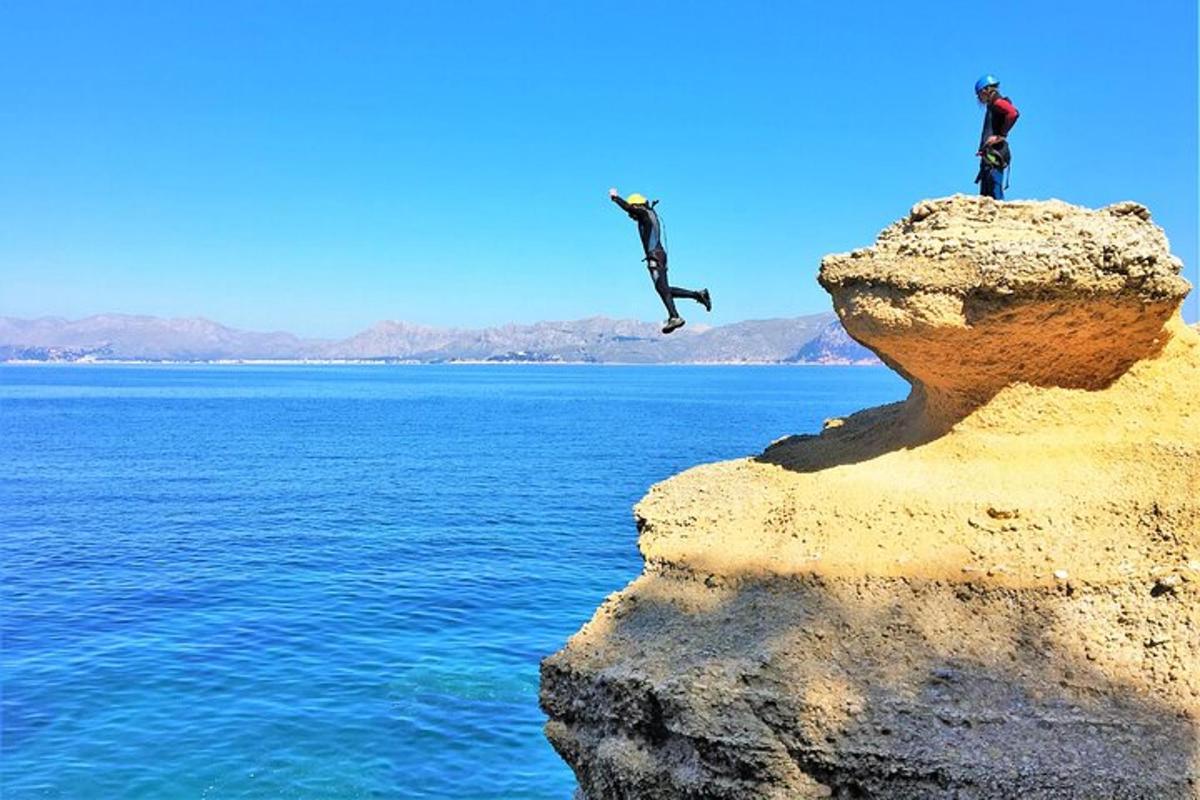 duas pessoas pulando de uma pedra na água