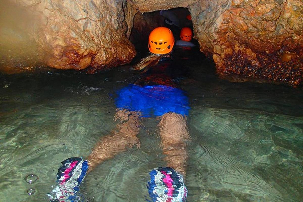 uma pessoa parada na água em uma caverna