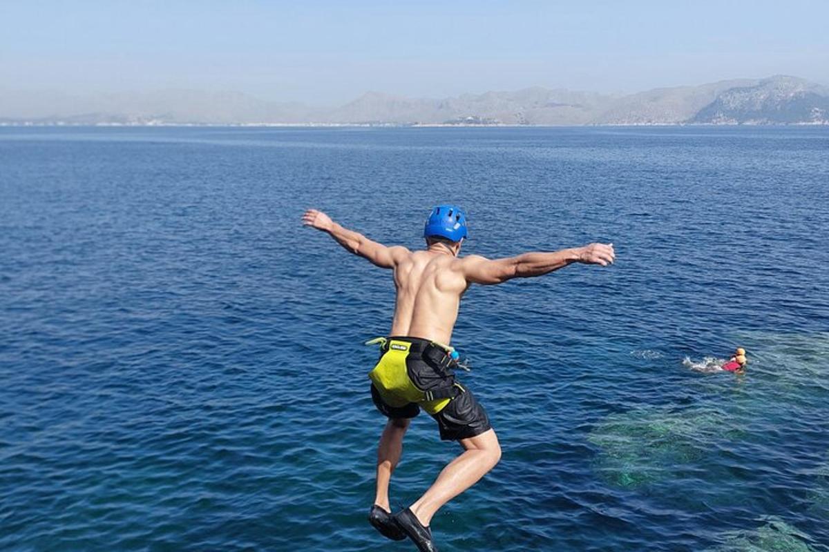 um homem pulando na água do oceano