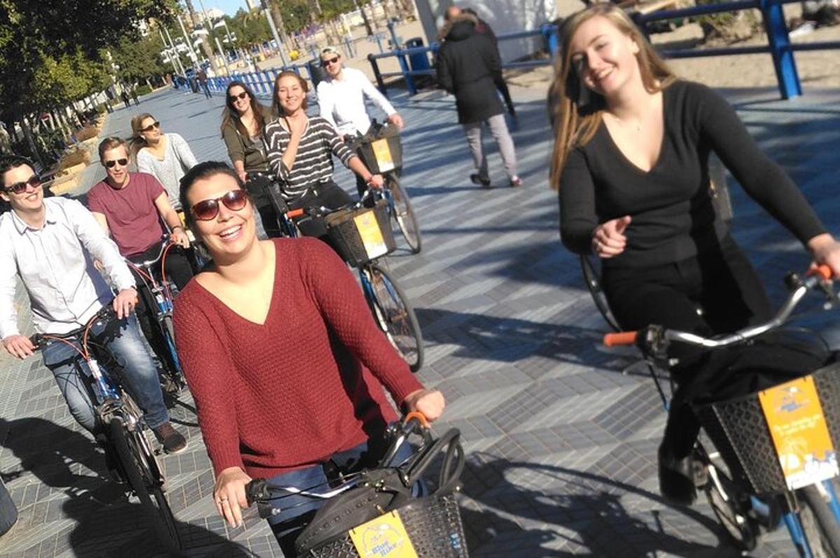 un gruppo di persone in bicicletta lungo un marciapiede