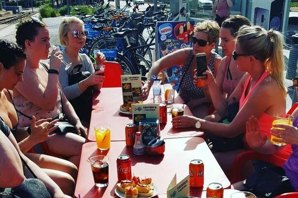 un gruppo di persone sedute attorno a un tavolo con delle bevande