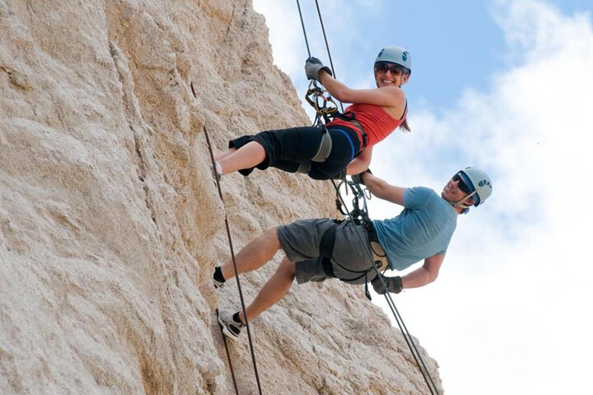 a man and a woman climbing a rock wall