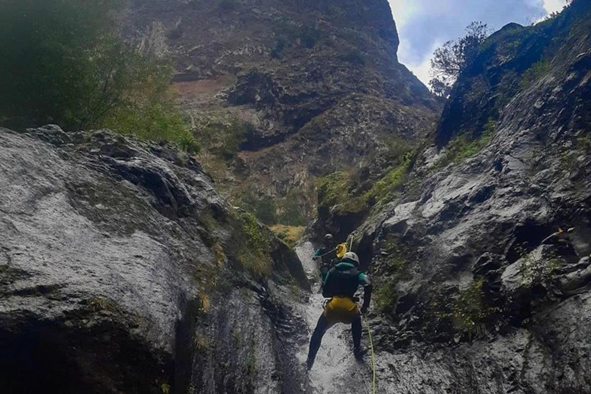un uomo che cammina lungo un sentiero di montagna roccioso