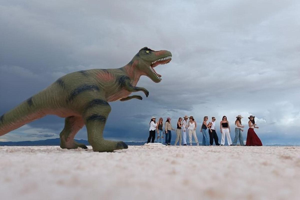 skupina lidí stojící vedle sochy dinosaura