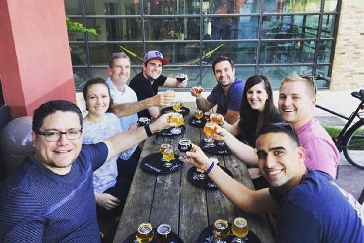 un gruppo di persone sedute attorno a un tavolo a bere birra
