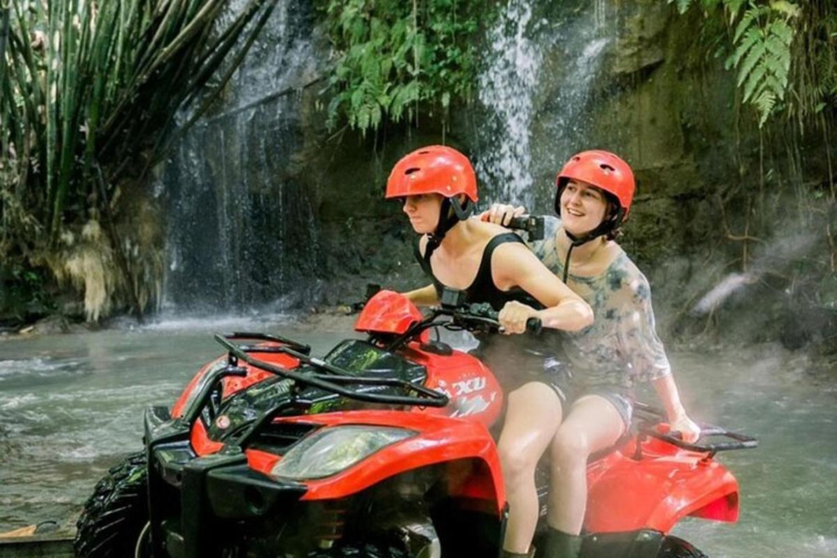 hai cô gái trên xe địa hình trước thác nước
