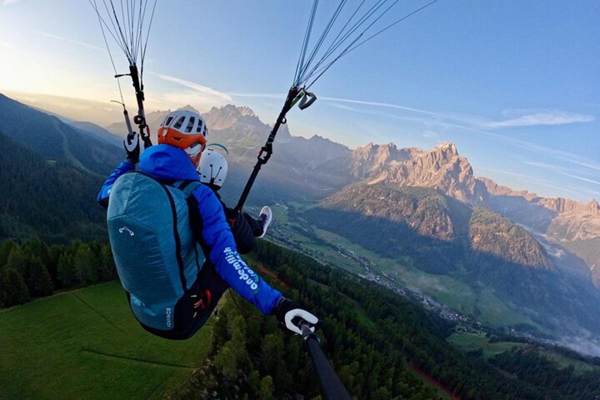 a person hanging from a parachute in the mountains