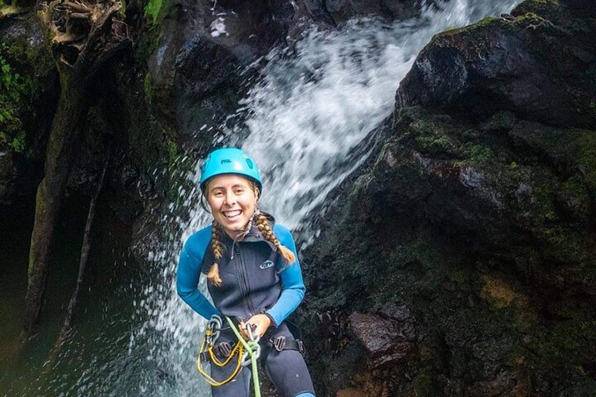 eine Frau steht vor einem Wasserfall