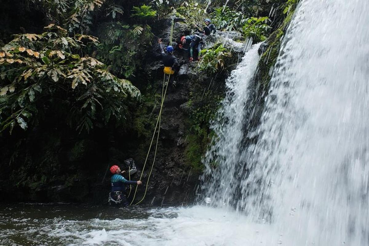 eine Gruppe von Menschen steht am Fuße eines Wasserfalls