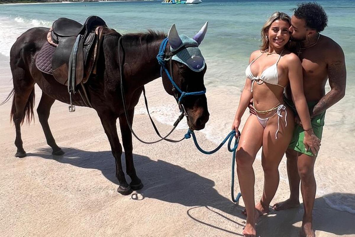 Maður og kona í bikiní með hesti á ströndinni