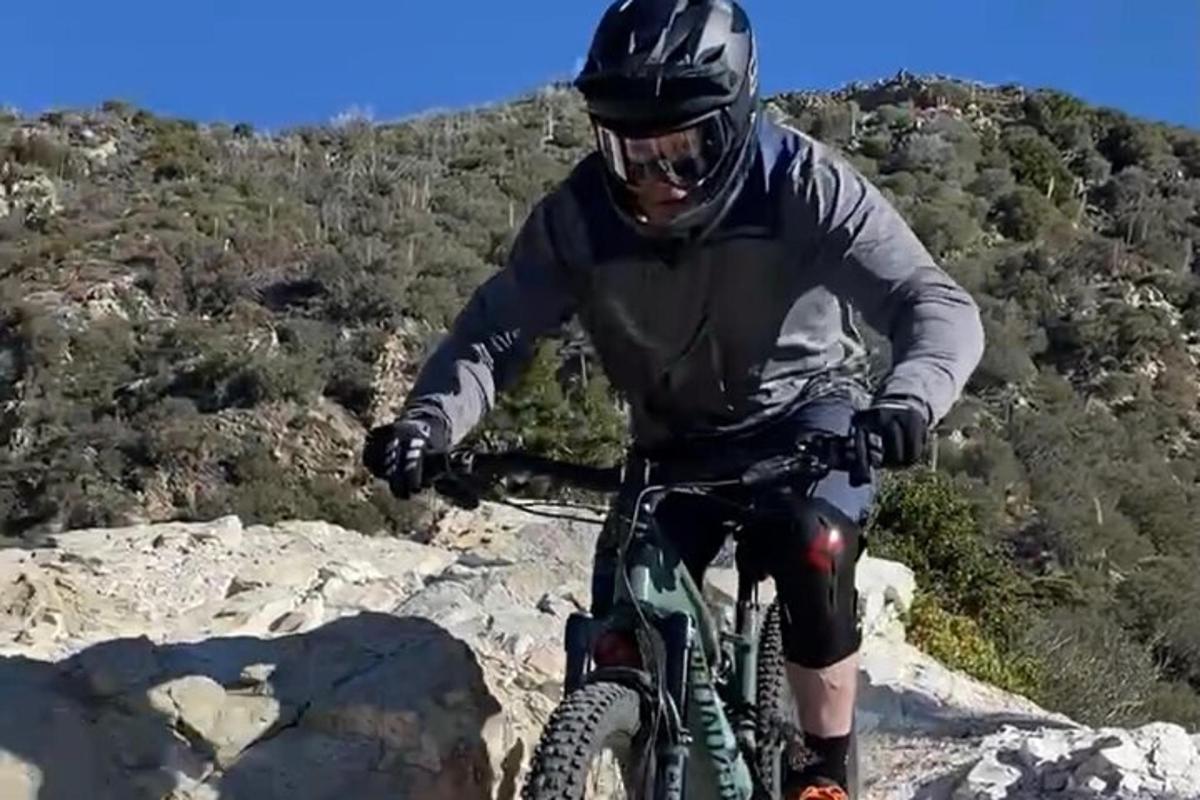 un hombre montando en bicicleta en la cima de una montaña