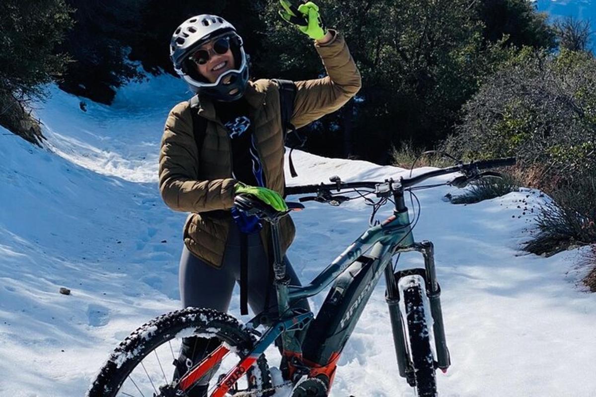 una persona sosteniendo una bicicleta en la nieve
