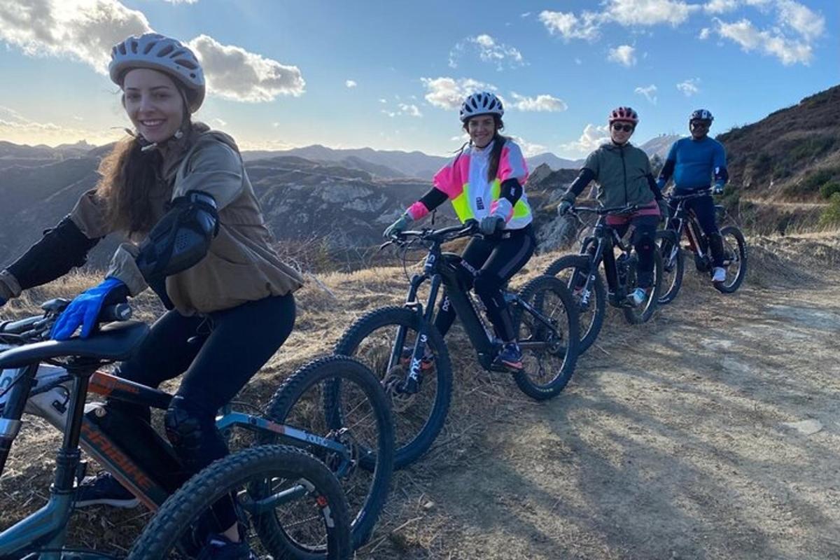 a group of people riding bikes on a dirt road