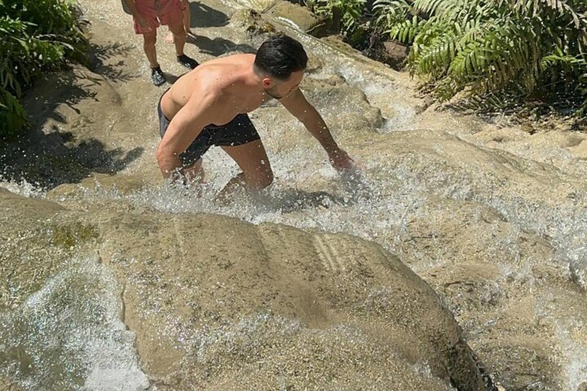 a man playing in the water in a waterfall