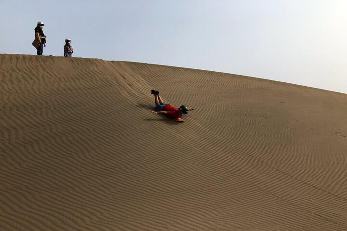 dos personas en la cima de una duna de arena