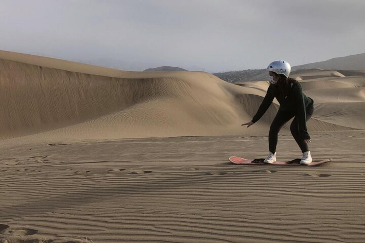 osoba stojící na snowboardu v poušti