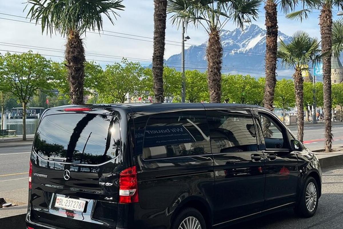 črn terenec parkiran na ulici s palmami