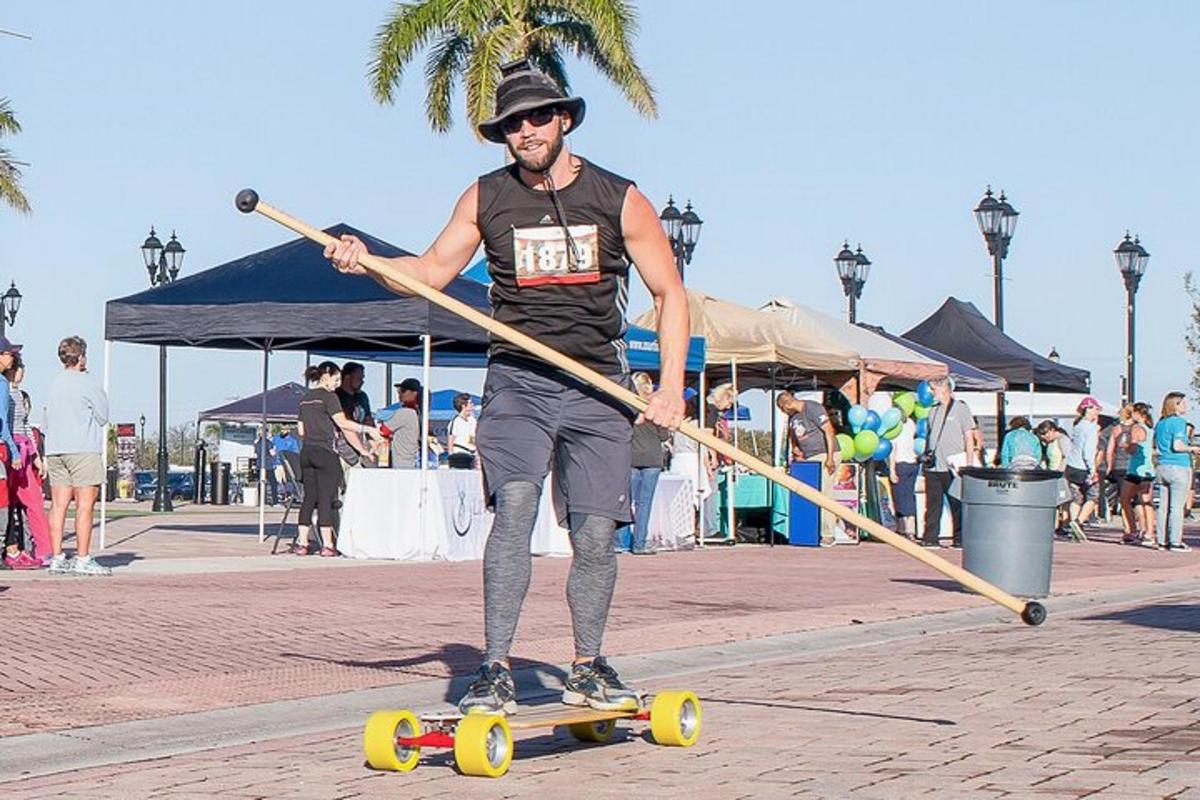 a man riding a skateboard while holding a stick