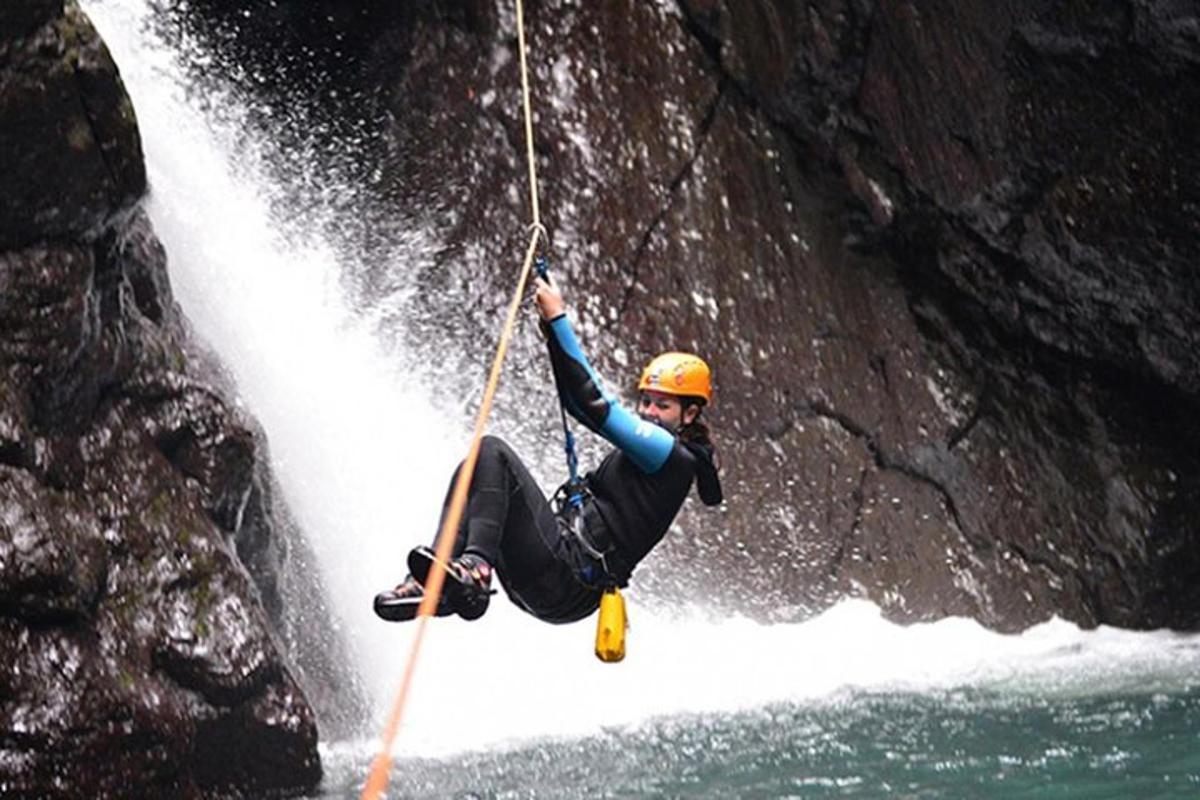 un uomo tiene una corda mentre cavalca una cascata
