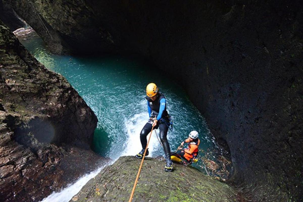 Dos personas de pie sobre una roca en una cueva.