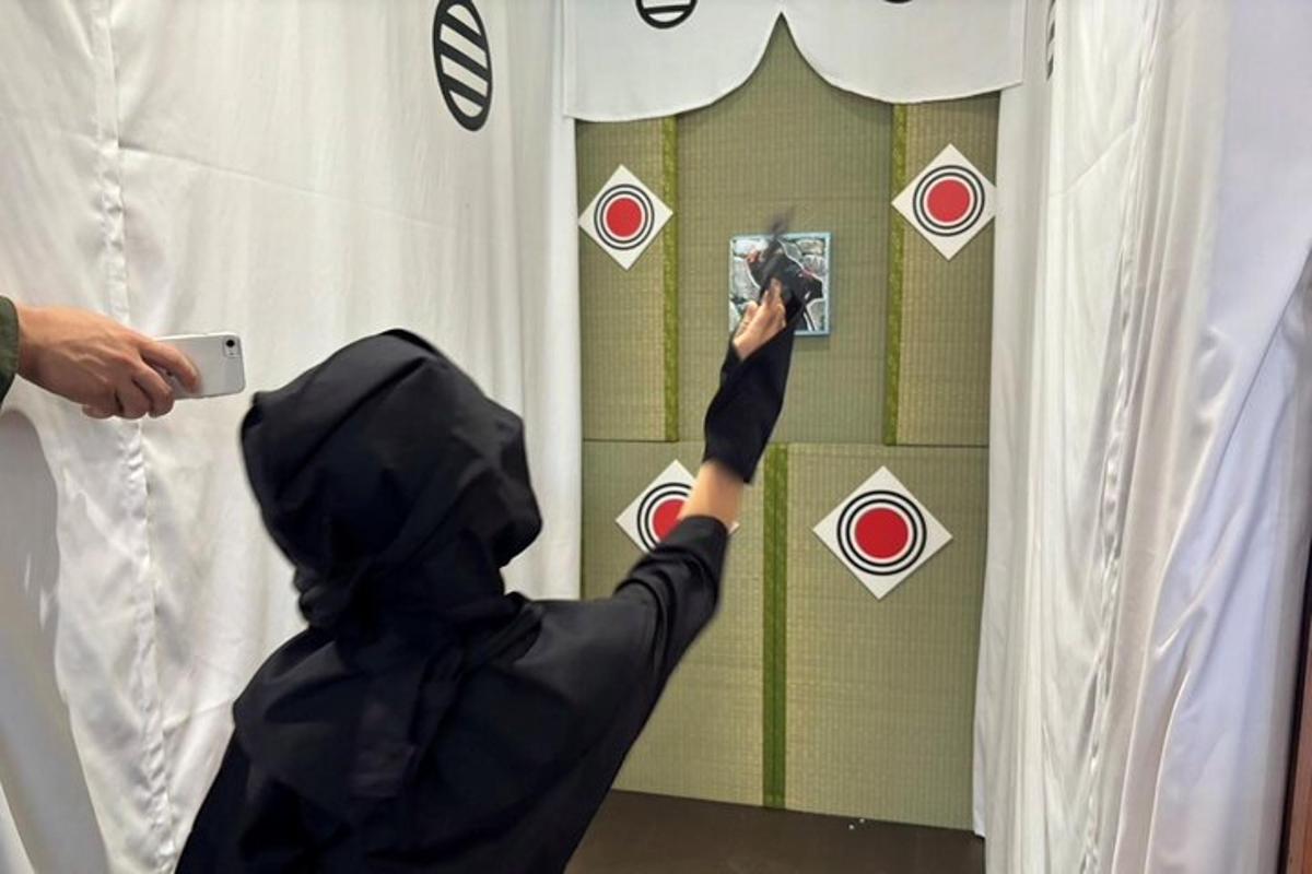 Una persona de negro tomando una foto de una ventana.
