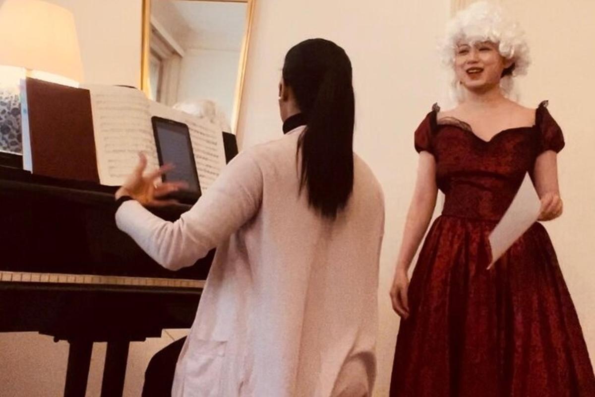 una donna in piedi accanto a una donna davanti a un pianoforte