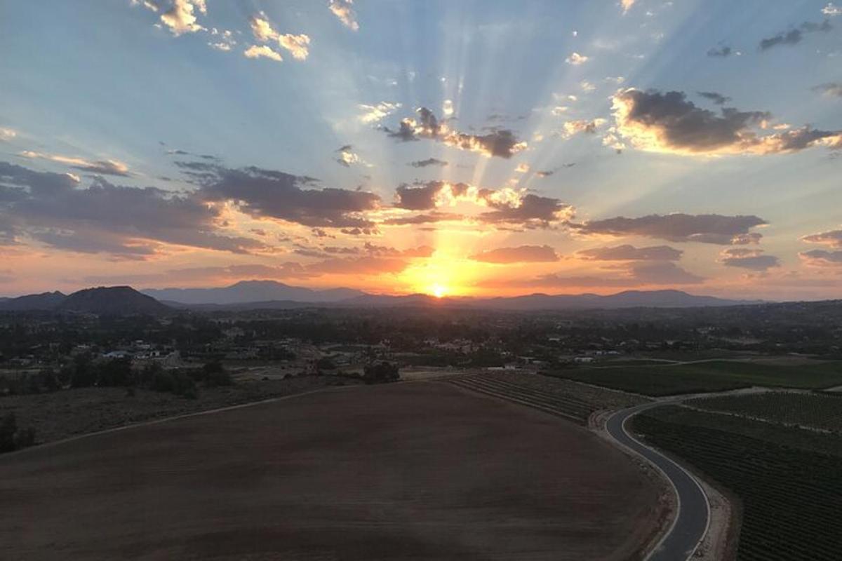 zalazak sunca nad poljem sa suncem na nebu