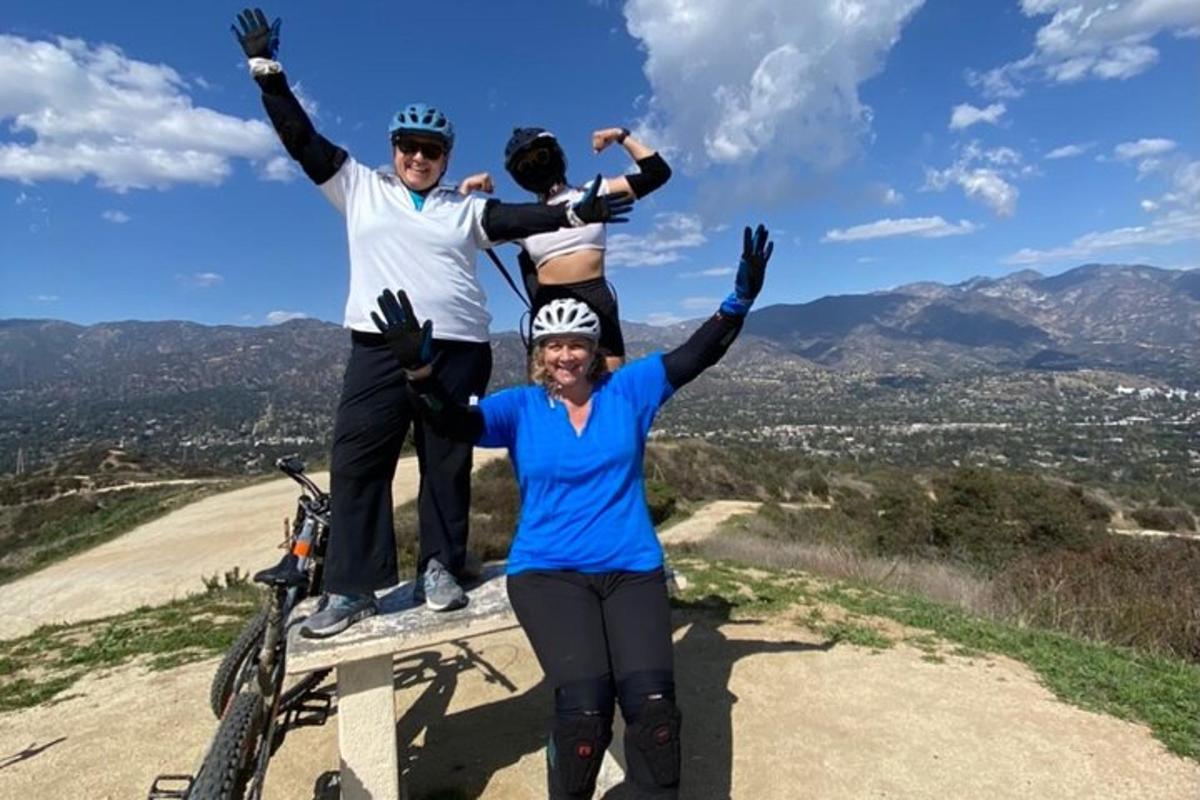 two people standing on top of a mountain with their arms up