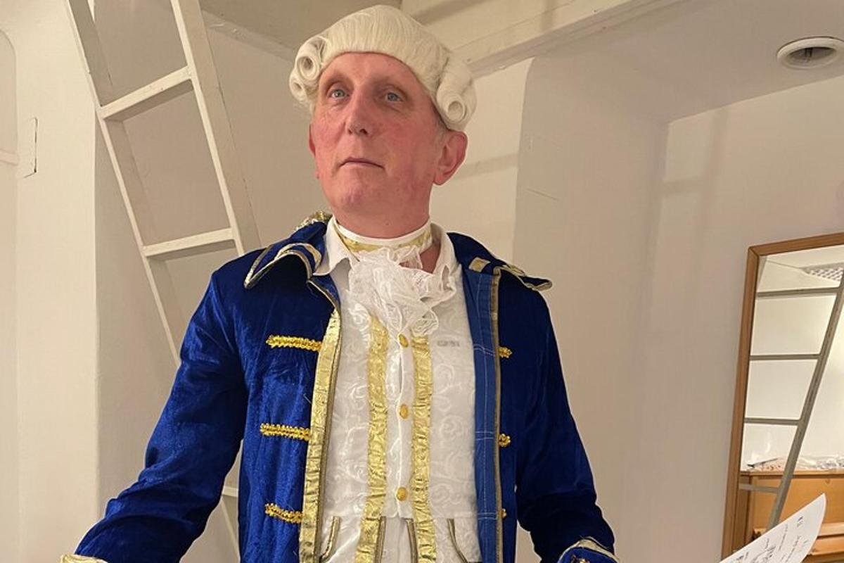 un uomo che indossa un cappello e una giacca blu