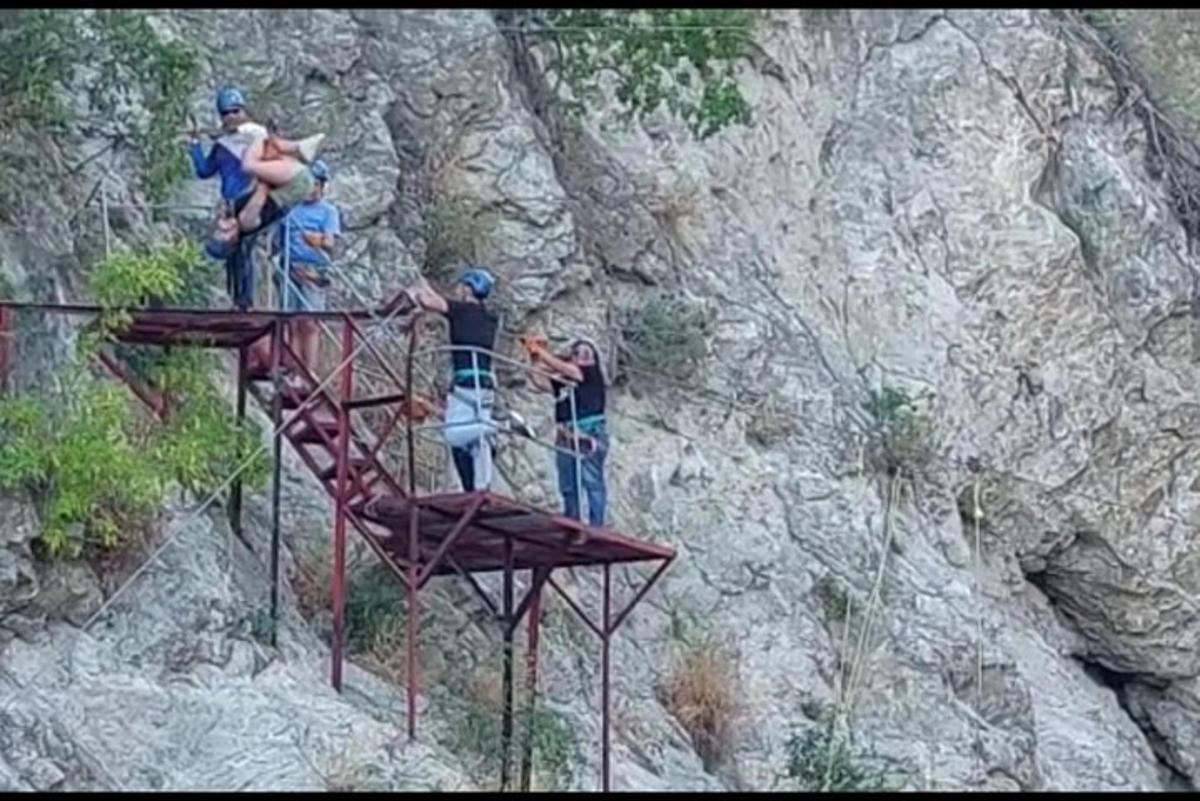 skupina lidí stojících na kovové konstrukci na hoře