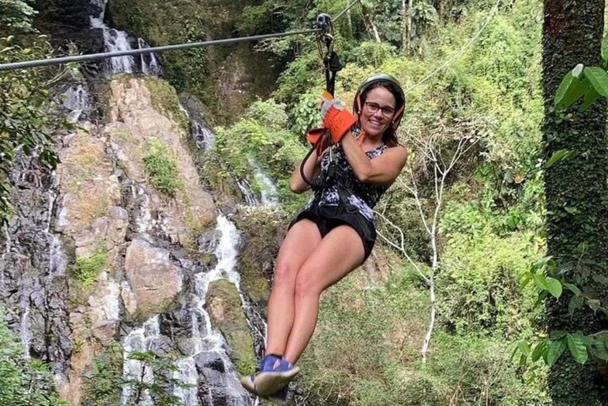 een vrouw op een zipline voor een waterval