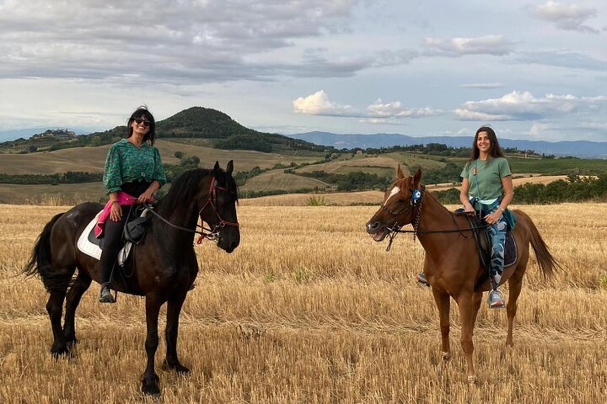 zwei Frauen reiten auf Pferden auf einem Feld