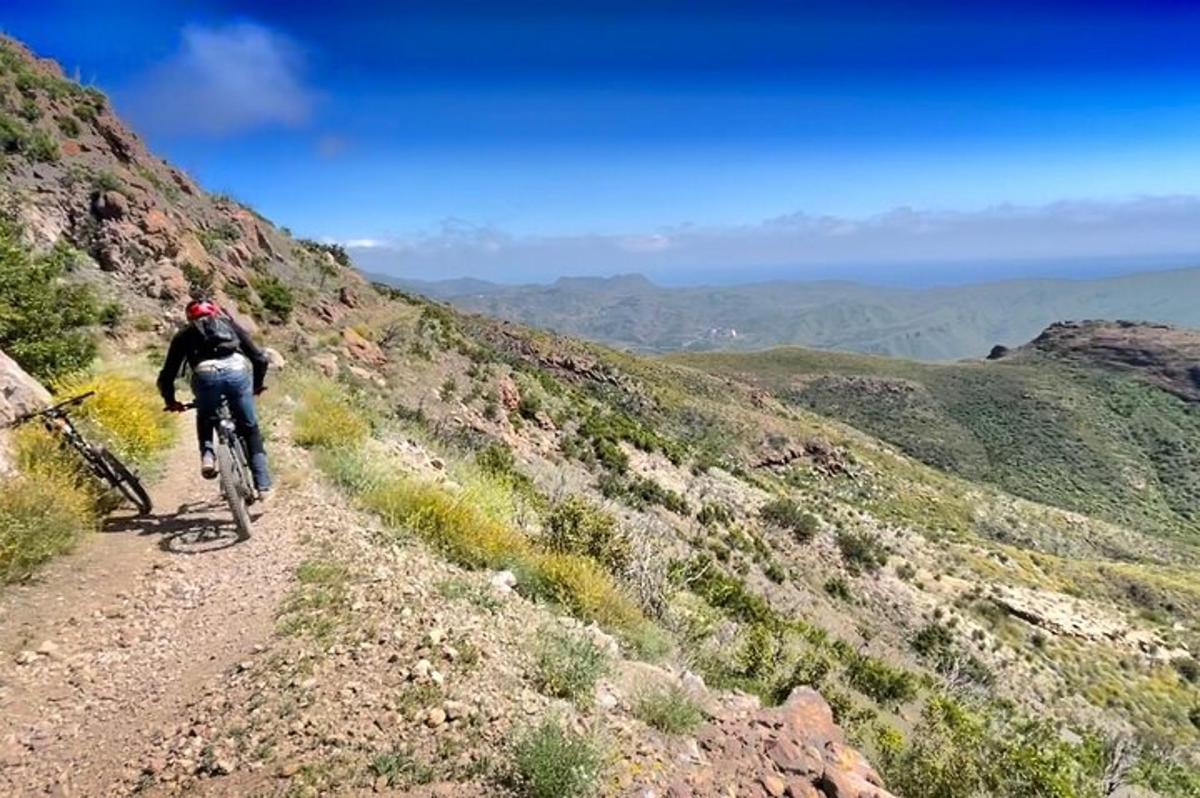 una persona che va in bicicletta lungo una strada sterrata