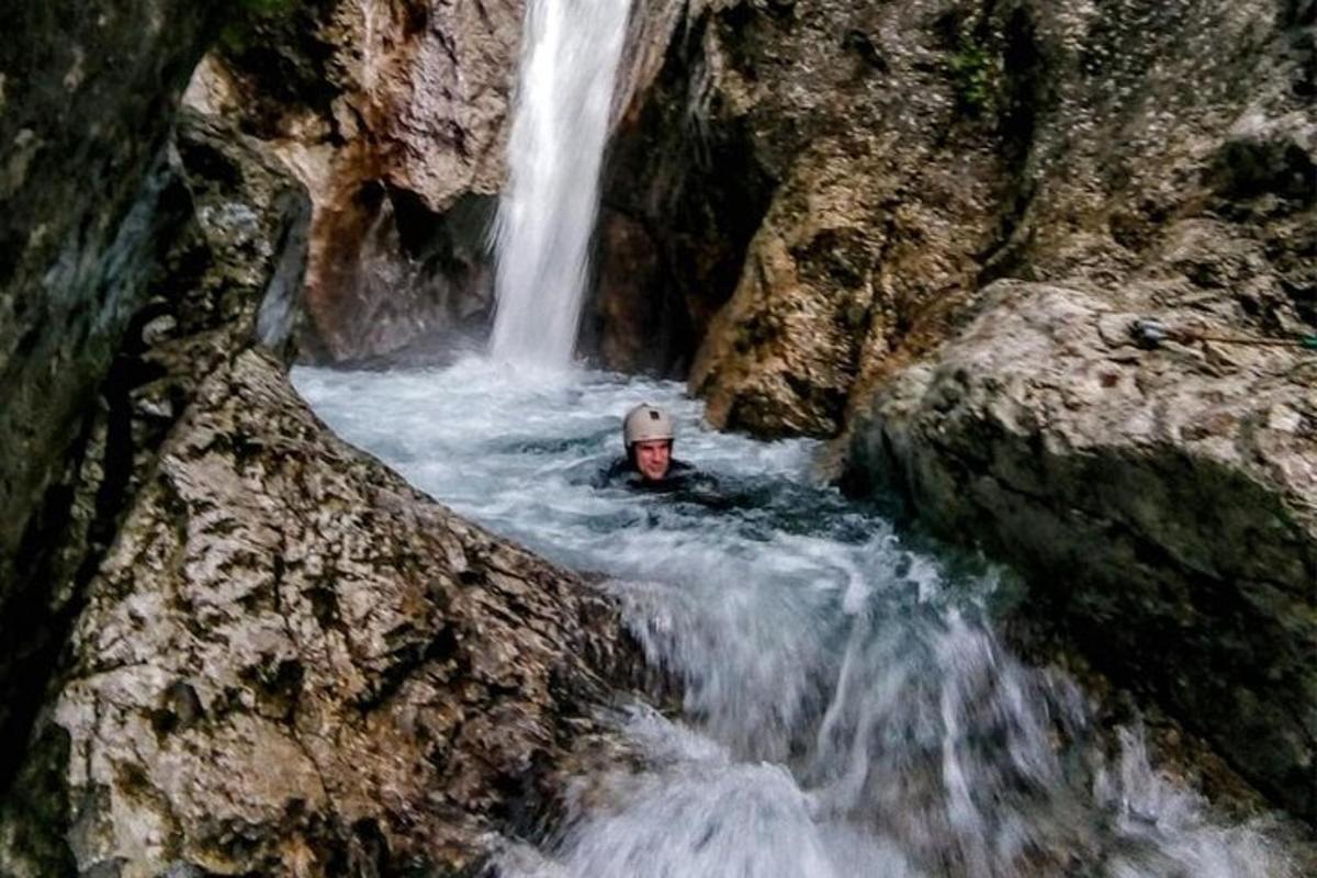 a man is swimming in a waterfall