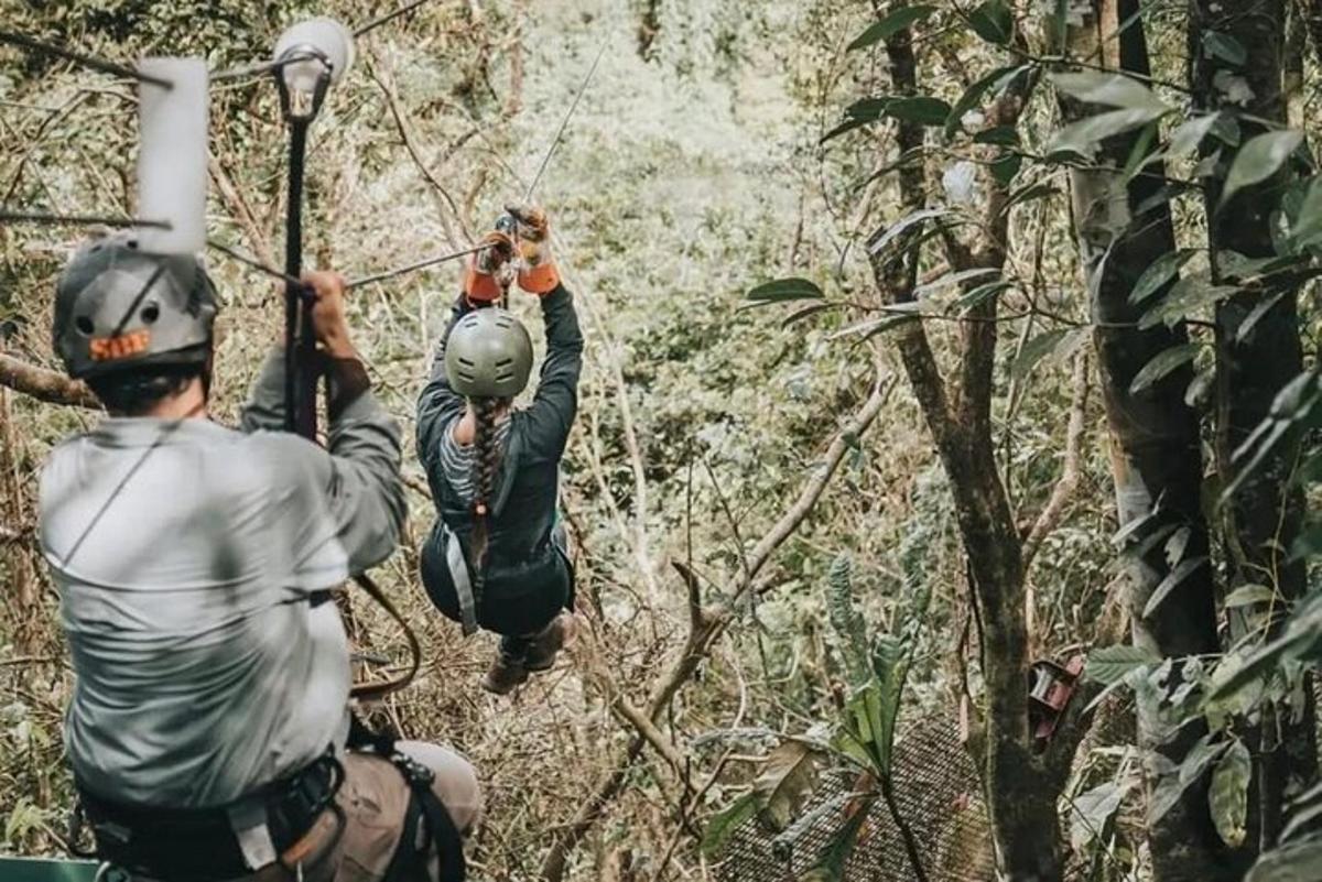 zwei Personen auf einer Seilrutsche im Dschungel