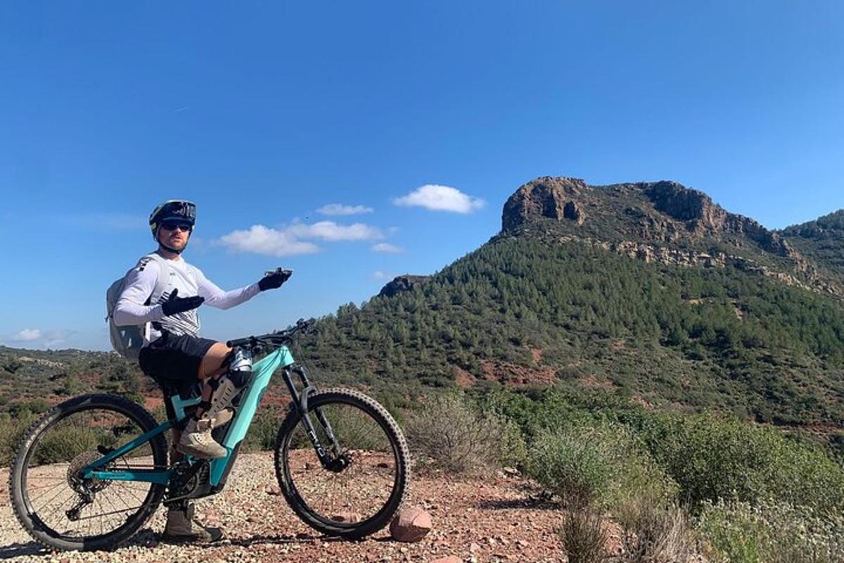 een man die op een fiets op een berg staat