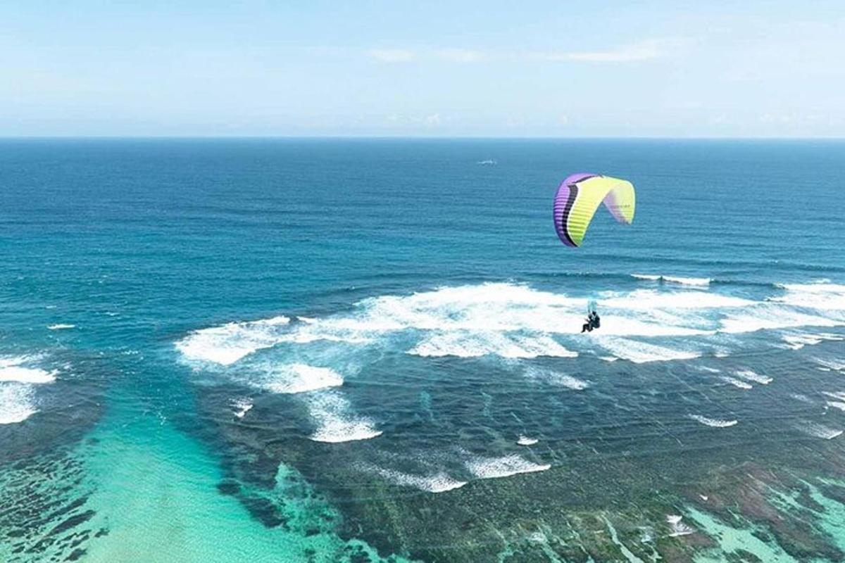 una persona che fa volare un aquilone sopra l'oceano