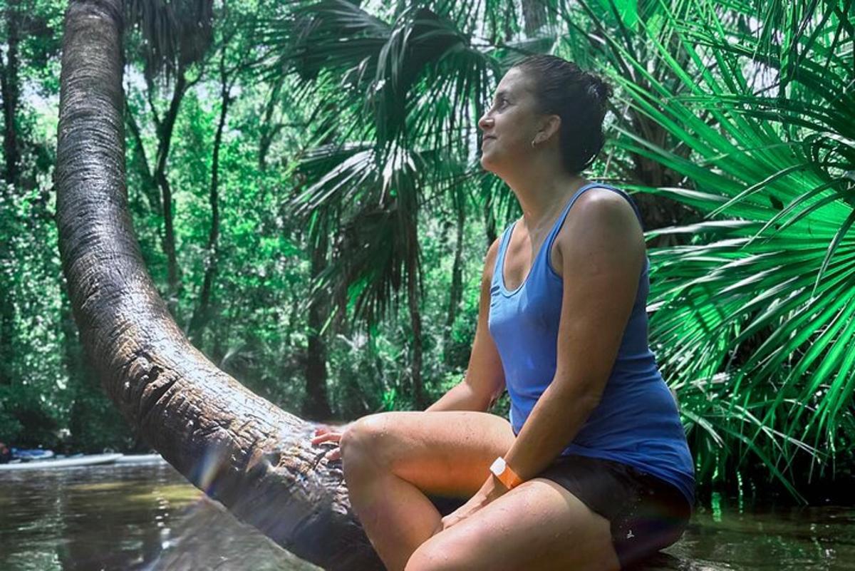 una donna seduta su un albero nella giungla