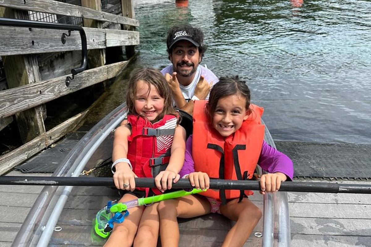 Un hombre y dos niñas sentados en un bote de remos