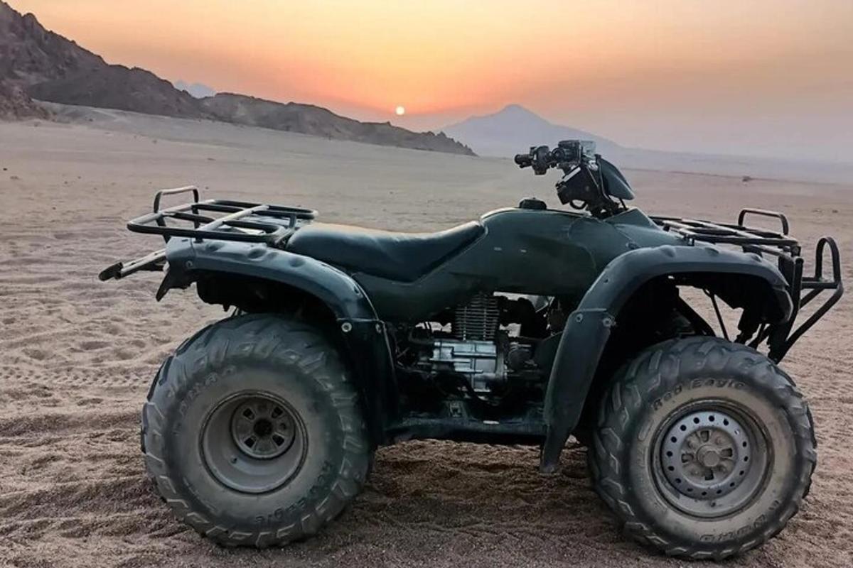 egy ATV parkolt a sivatagban naplementekor