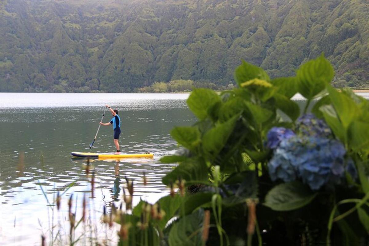 una persona in piedi su una tavola da paddle su un lago