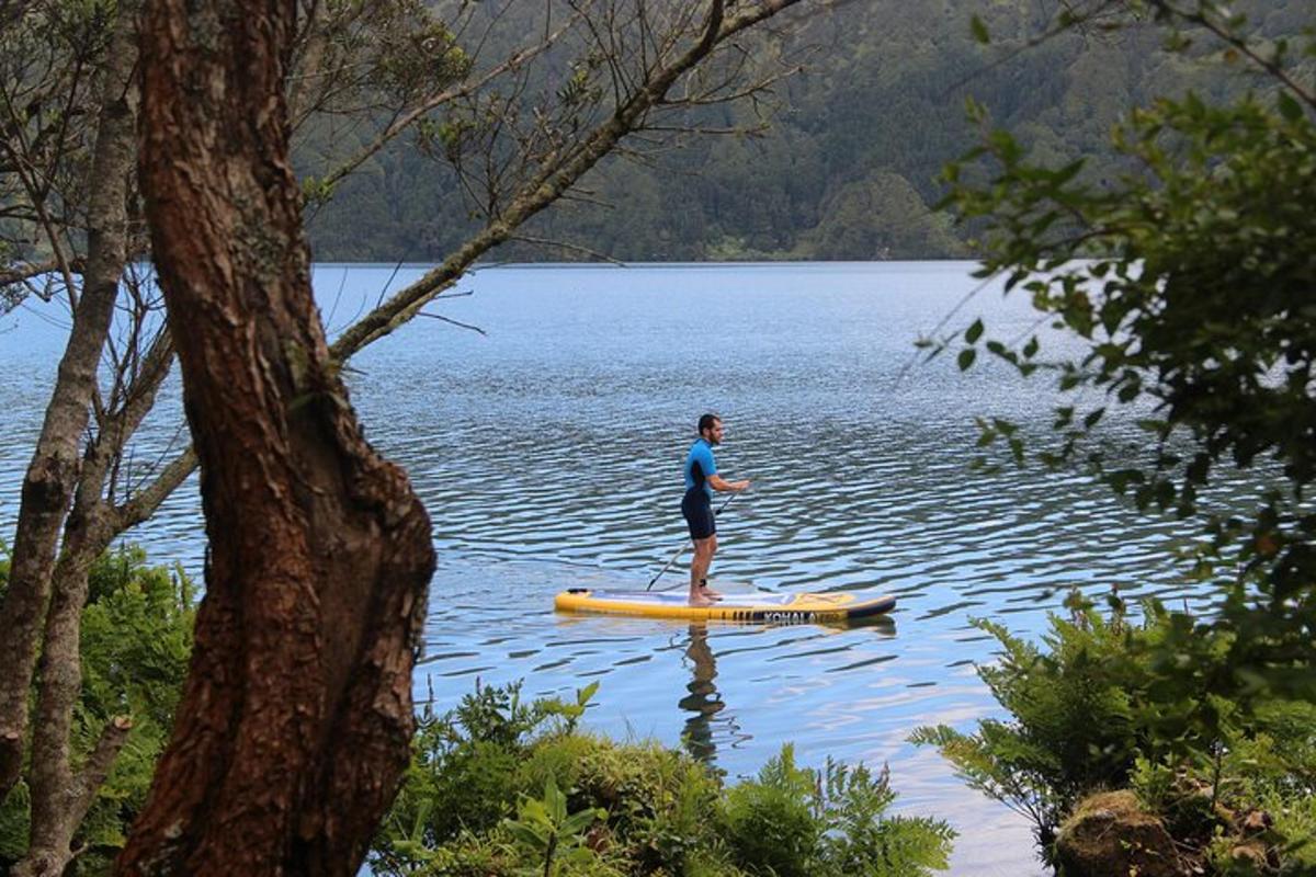 un uomo in piedi su una tavola da paddle su un lago