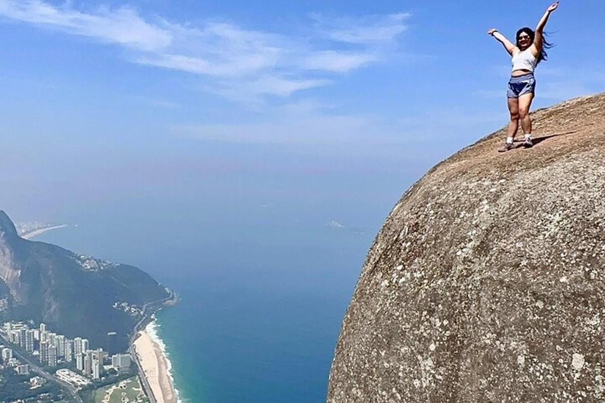 a woman standing on the edge of a mountain