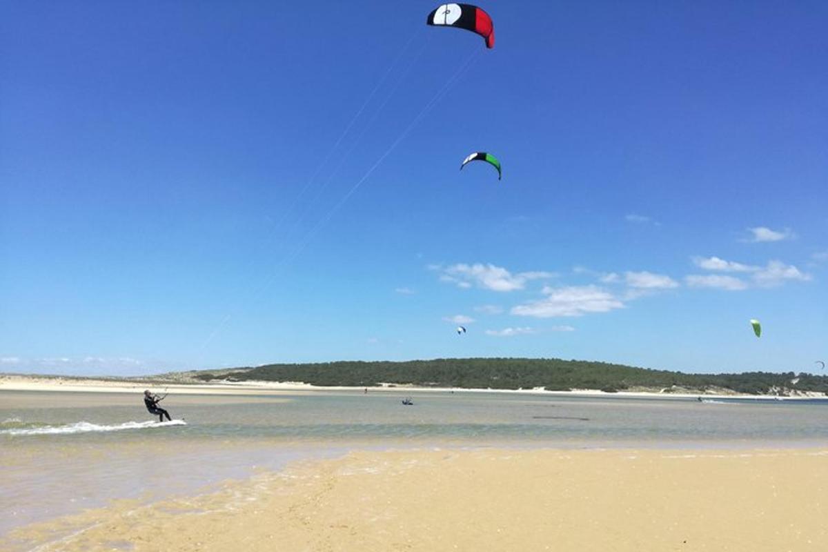 Una persona practicando kitesurf en el agua de una playa.